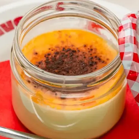 Panna cotta nel barattolo di vetro, sul piattino con il tovagliolo rosso