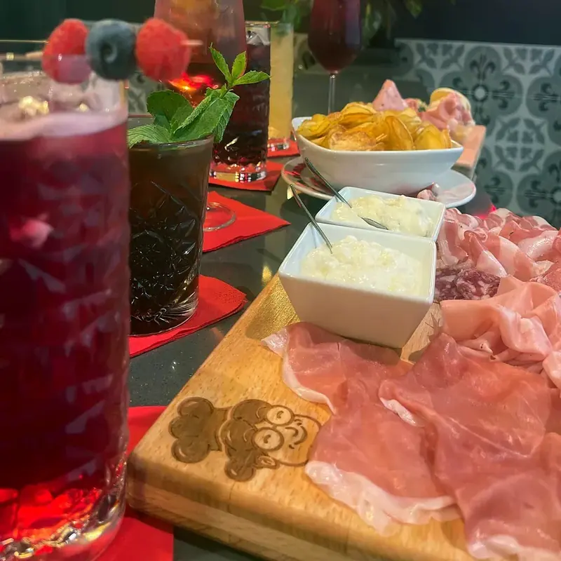 Un tagliere con gnocco fritto, crudo e mortadella accanto ai cocktail sul mio bancone
