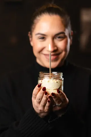 Una candelina accesa su un dolce nel barattolo, per un compleanno